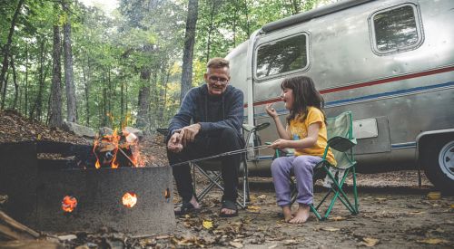 un adulte et un enfant assis autour d'un feu de camp